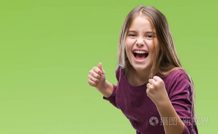 年轻漂亮的女孩在孤立的背景下,非常高兴和兴奋地做胜利者的手势,举起