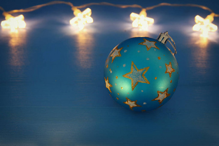 形象圣诞树球装饰与金色星星前蓝色背景。