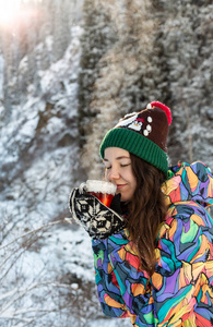 女孩喜欢雪落。在一次降雪过程中，森林正在喝茶了针织的形状的年轻女子。健美的照片