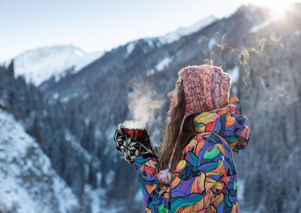 女孩喜欢雪落。在一次降雪过程中，森林正在喝茶了针织的形状的年轻女子。健美的照片