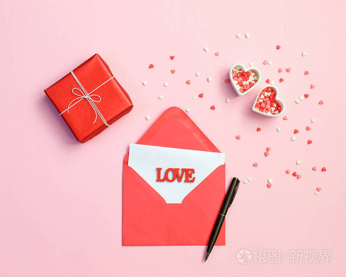 信封, 钢笔, 礼品盒和红色的心粉红色的背景。爱的概念。爱的概念。圣瓦伦丁节