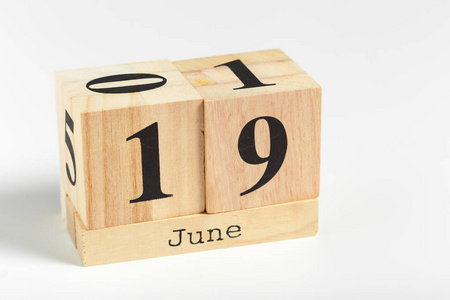 白色背景上有日期的木制立方体。 六月十九日