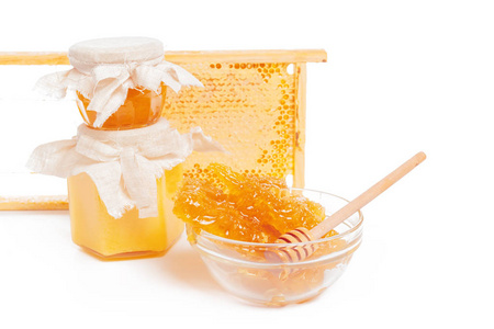 蜂蜜罐和白色背景上隔离的棍子