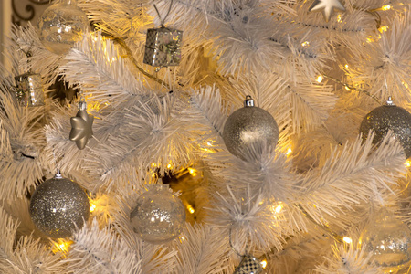节日的一部分装扮成白色的圣诞树。 银球点亮星星礼盒。 令人难以置信的节日气氛舒适和温暖的装饰品
