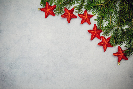 圣诞节背景与冷杉树和红色闪亮的星星在灰色混凝土桌子上。 顶部视图与复制空间。