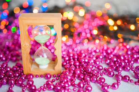 圣诞装饰品圣诞树分枝和粉红色的球在白色背景。沙漏和新年礼物。云杉上的圣诞装饰品的红色项链。复制空间