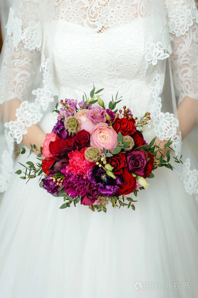 新娘手捧一束鲜花,手捧一束乡村风格的婚礼花束