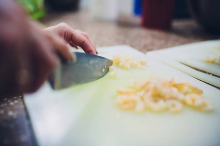 用刀在白色切菜板上烤虾做饭