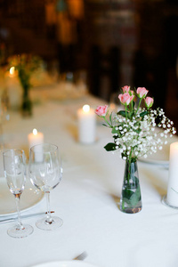 白色桌上的鲜花盘子和蜡烛花束