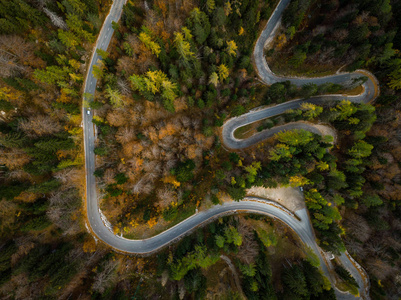 蜿蜒的道路在山上，秋天的林地，无人机从上面看。