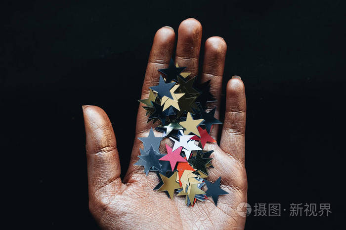 女性手拿星星五彩斑斓的黑色背景