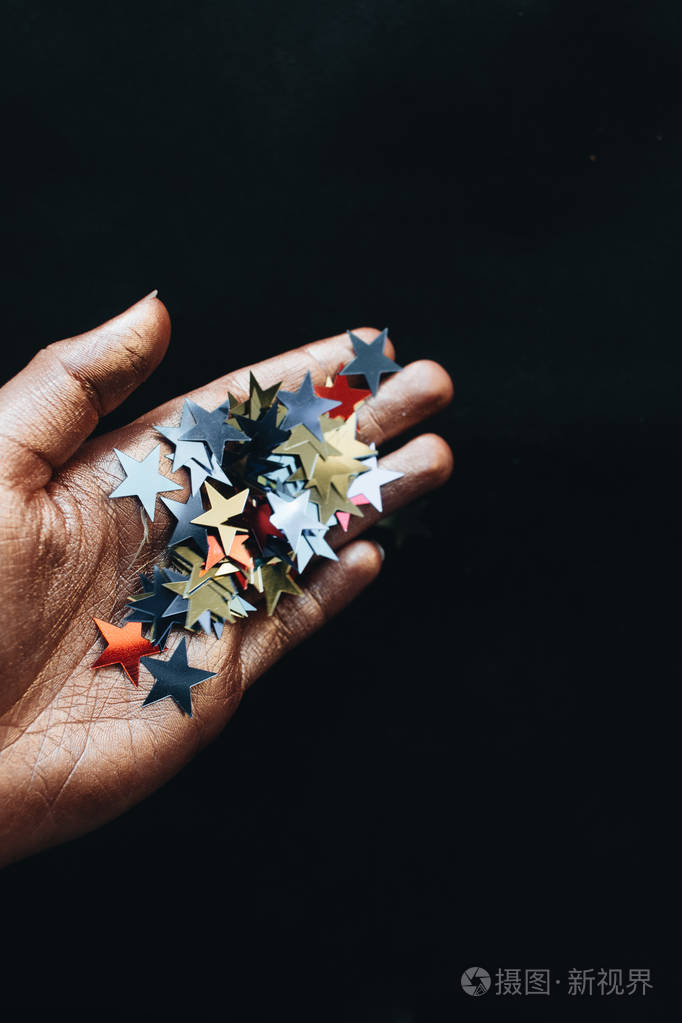 女性手拿星星五彩斑斓的黑色背景