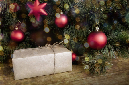 圣诞礼物。 圣诞构图由冷杉树枝珠宝和木制背景上的老式礼品盒组成。