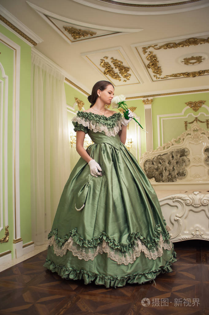 复古巴洛克时尚女性肖像,穿绿色复古礼服在旧宫室内