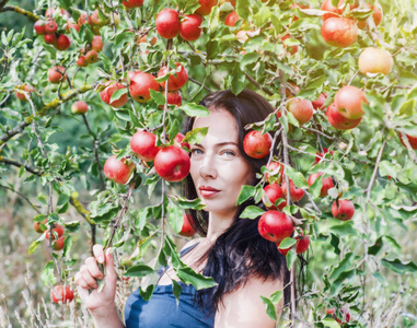 野生苹果园里的深色头发。 背景上的肖像苹果分公司。 女性的。 夏天的记忆。 时尚前夜。 自然自然自然