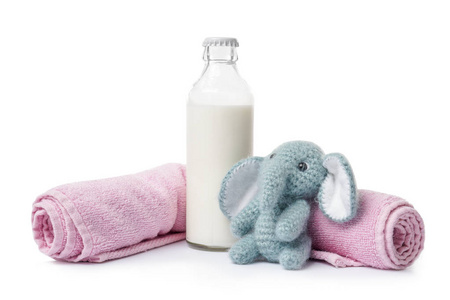 带毛巾和白色背景玩具的牛奶瓶