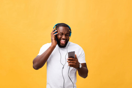 年轻的非洲裔美国人戴着耳机, 享受金色的音乐背景