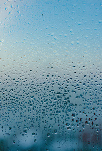 扭曲的玻璃背景。冬季湿度大.水滴从家里凝结在窗户上