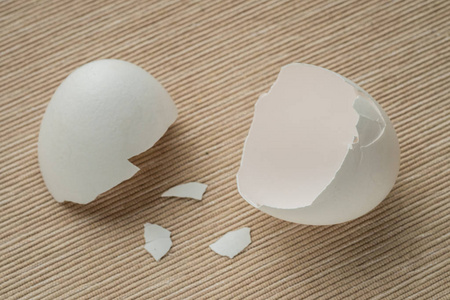 鸡蛋和鸡蛋壳靠近。 裂开的半个蛋壳开口。