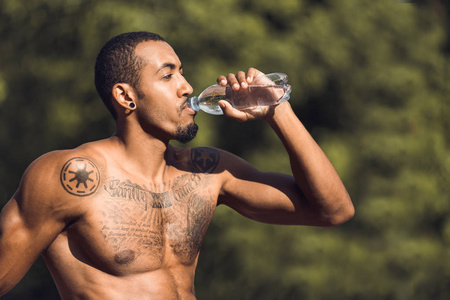 运动男子在户外锻炼后喝水