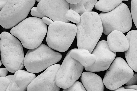 白色鹅卵石背景。 黑色背景上的白色石头