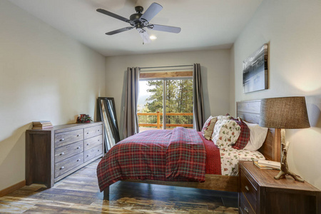 宁静的乡村卧室配有木制主床深灰色梳妆台和宽敞甲板的景色