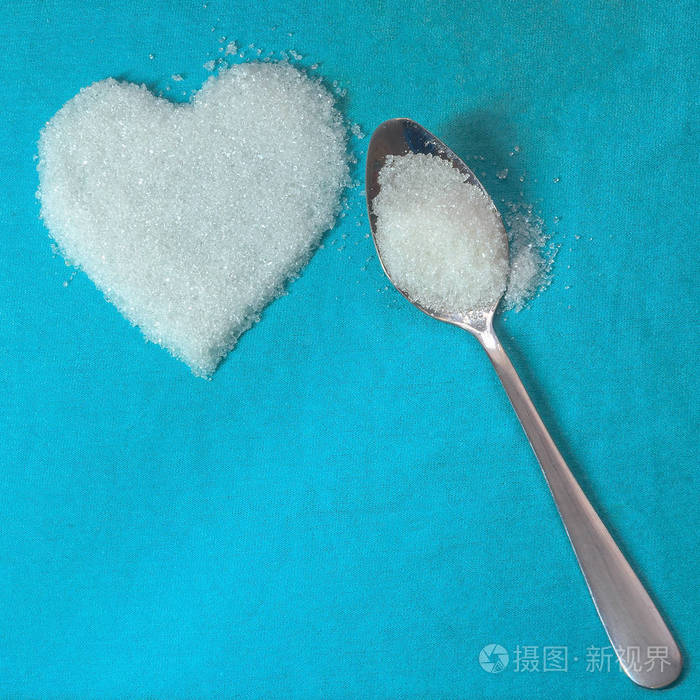 在蓝色织物背景上用一勺糖和雪白的糖心的方形框架