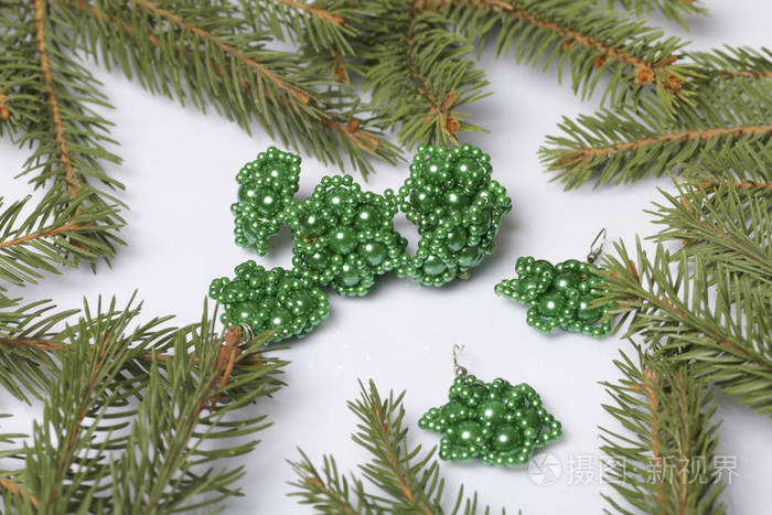 s earrings and beaded bracelet among the branches of spruce. On 