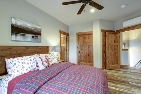 提供木制主床和红色床上用品的乡村卧室