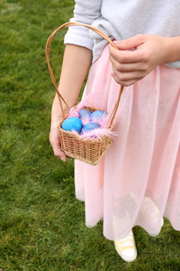 女人在户外拿着柳条篮子和复活节彩蛋