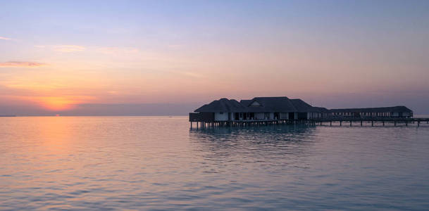 令人难以置信的橙色日落在绿松石泻湖与水平房在马尔代夫