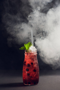 黑暗和暴风骤雨的朗姆酒鸡尾酒草莓对背景烟雾