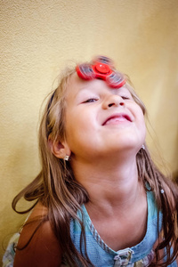 小女孩玩红色烦躁旋转玩具，以减轻家里的压力。