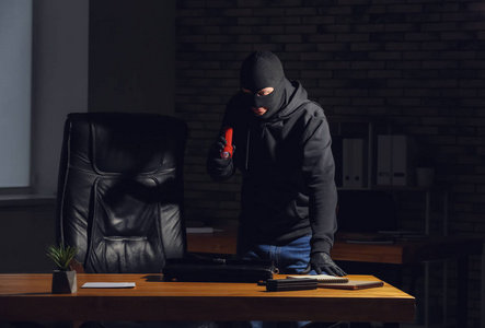 头盔与面罩,制备的示范办公室里拿着手电筒的男小偷非法的橡皮戳旧