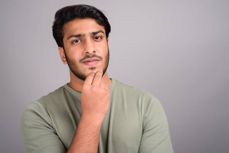 印度休闲男性的思维年轻英俊的印度男人的画像在灰色背景照片