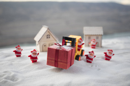 微型礼品盒由叉车在雪地上确定圣诞假期的形象和新年快乐礼物庆祝的概念。 选择性聚焦