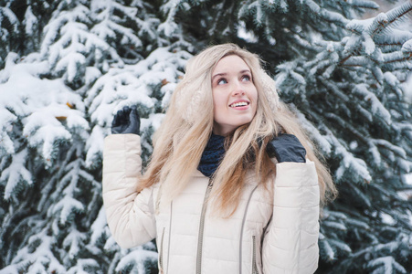 美丽的微笑的女人在户外玩雪的乐趣。 寒假。