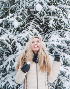 美丽的微笑的女人在户外玩雪的乐趣。 寒假。