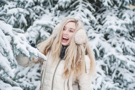 美丽的微笑的女人在户外玩雪的乐趣。 生活方式。 寒假。