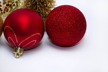 圣诞玩具两个闪亮的红色球和一棵金色的圣诞树在背景上。 新年。 在灰色背景侧视图上。