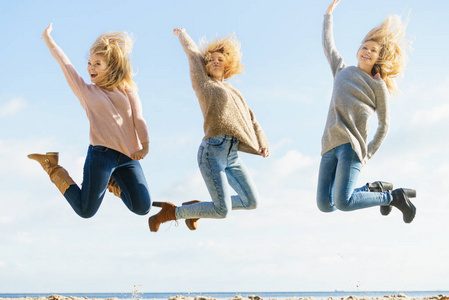 三个充满喜悦的女人在背景中跳跃着。女性朋友在户外玩得很开心。