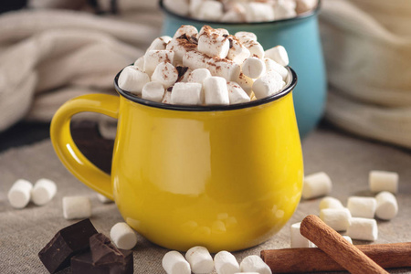 一杯热巧克力，上面有棉花糖，在巧克力和肉桂的背景上有一根棒棒糖棒。 舒适温暖的冬季乡村情调作文