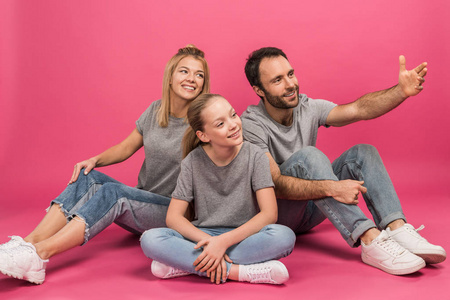 幸福的家庭，女儿坐在粉红色，而父亲展示了一些东西