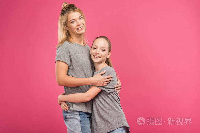 可爱的女儿拥抱妈妈孤立的粉红色