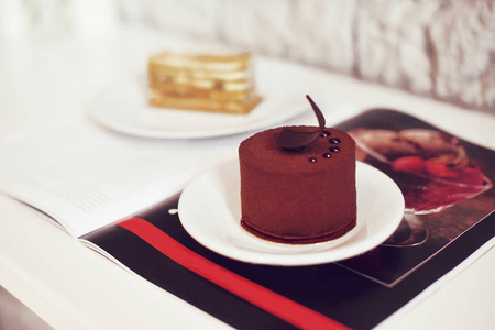 美食巧克力甜点在餐馆咖啡馆。烹饪一本甜点的书。