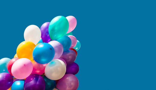 一群五颜六色的气球在蓝天背景上与复制空间