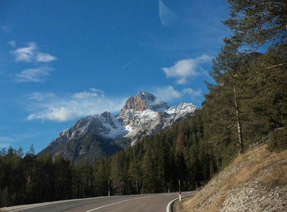 旅行。美丽的风景。阿尔卑斯山, 森林。蓝色的天空和道路