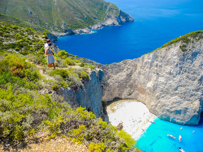 游客靠近克利夫边缘的沉船湾背景Zakynthos岛希腊。