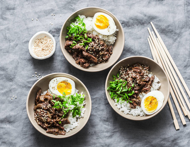 日本牛肉饭和煮鸡蛋碗灰色背景顶部视图. 亚洲食物概念平面照片