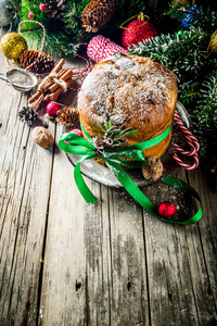传统的圣诞节帕内托尼与干果和坚果在旧的木制背景Wth圣诞装饰复制空间顶部视图。